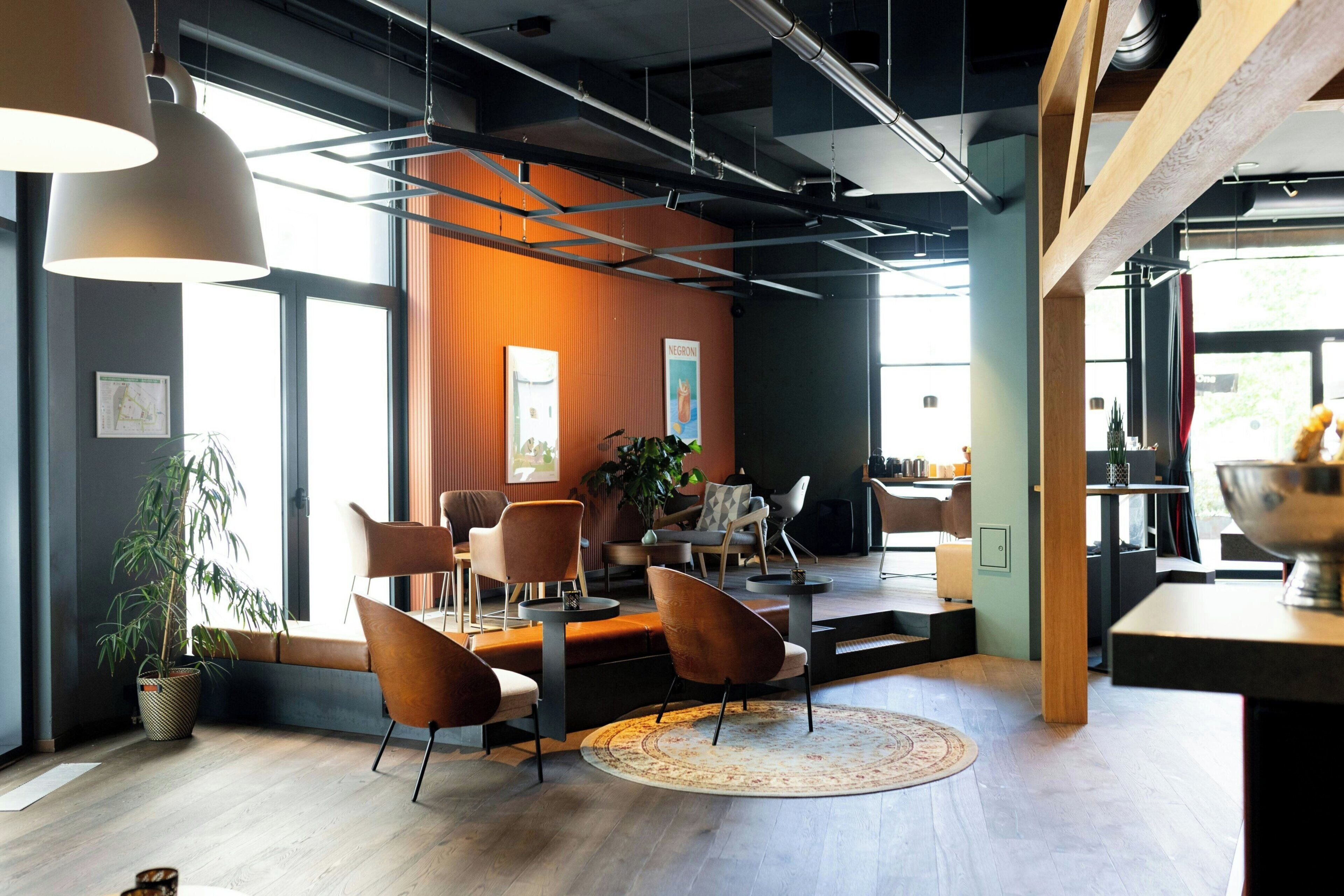 Un intérieur moderne avec un coin salon, de grandes fenêtres et un plancher en bois.