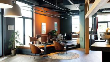 Un intérieur moderne avec un coin salon, de grandes fenêtres et un plancher en bois.