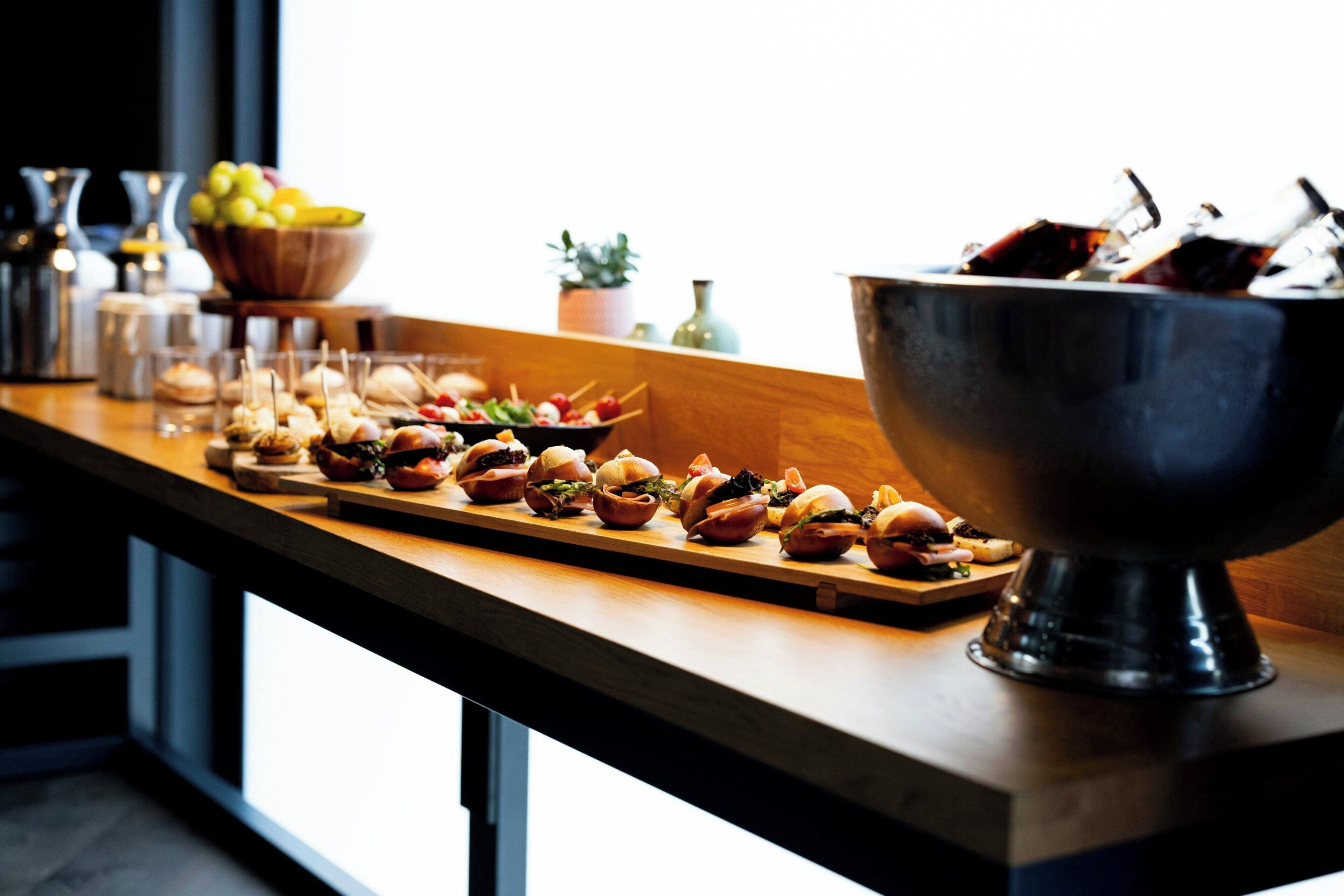 A buffet table with various food items and a large metal bowl.