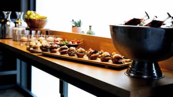 A buffet table with various food items and a large metal bowl.