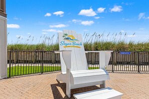A sign for Sugar Beach Condominiums with a beach theme, a maximum pool depth sign, and a paved walkway. - Ocean Seven Sugar Beach E7-Free Beach Chairs-Ground Floor-1Bd/1Ba/Sleeps 4-Walk to Beach (Panama City Beach)