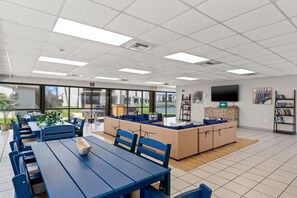 A spacious indoor area with a large seating area, a television, and a bookshelf. - Ocean Seven Sugar Beach E7-Free Beach Chairs-Ground Floor-1Bd/1Ba/Sleeps 4-Walk to Beach (Panama City Beach)