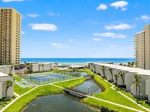A resort with a tennis court, a water canal, and a bridge.