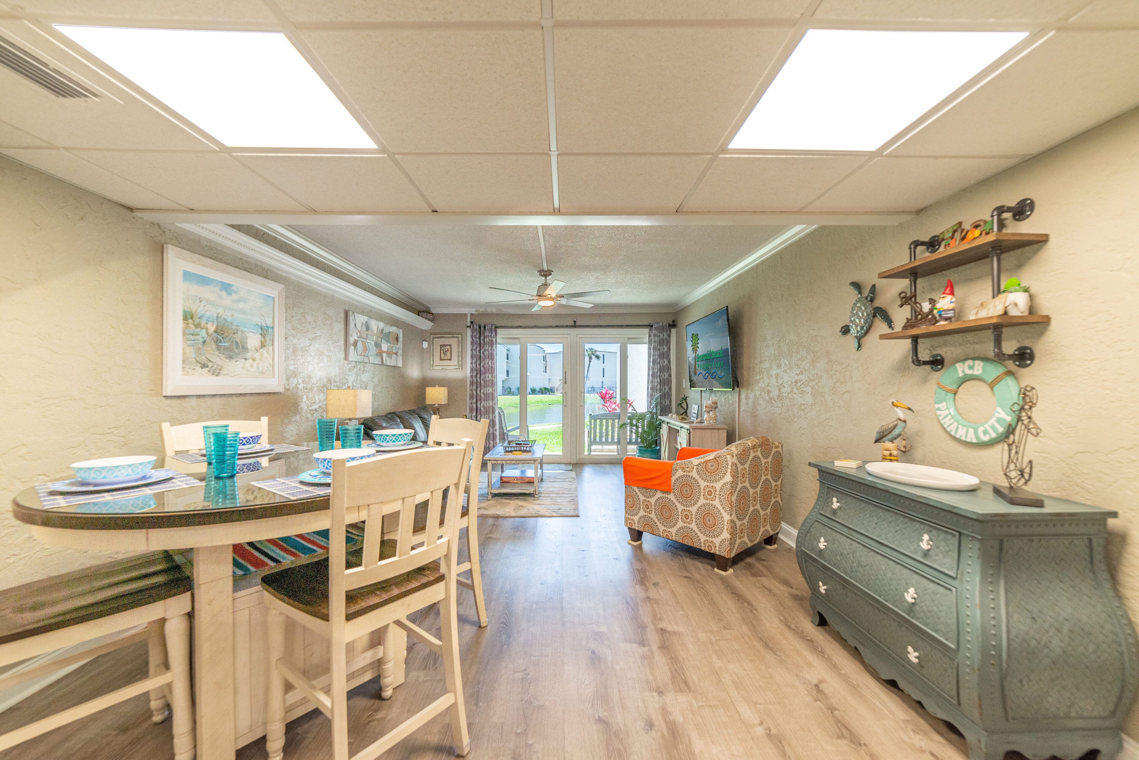 A spacious living area with a dining table, chairs, a sofa, and a green dresser.
