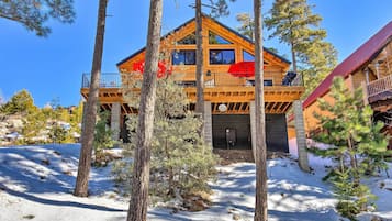 Guests can enjoy a balcony with outdoor seating overlooking the surrounding pine trees.