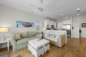 A modern living room with a sofa, a coffee table, and a dining area. - Townhome with stunning view of Matlacha Pass (Matlacha)