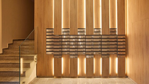 A modern hotel lobby with a wooden reception desk and a glass railing beside a staircase. - Promenada Studios (Brasov)