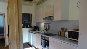 Uma cozinha compacta com pia, fogão e micro-ondas.