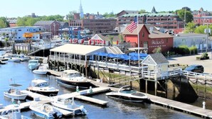 Un puerto deportivo con barcos amarrados, un muelle con zona de estar techada, y un edificio con un letrero que dice "Michael's HarborSide".