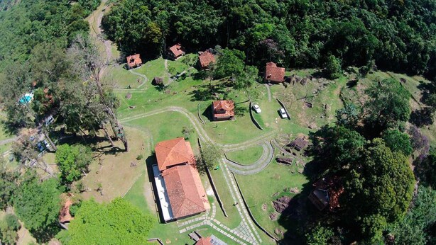 Vista aérea de una propiedad rural con varias construcciones, un camino sinuoso y vegetación circundante.