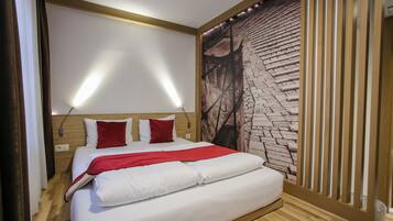Een moderne hotelkamer met een groot bed, een houten hoofdbord en een muurschildering van bakstenen.