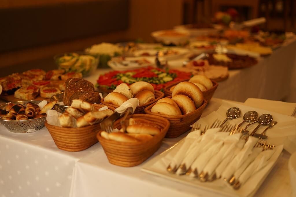 A buffet table with various food items and utensils.