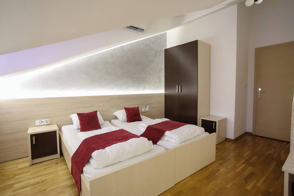 Un dormitorio moderno con una cama grande, un armario, una mesita de noche y una estantería empotrada.