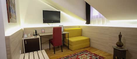 Una habitación pequeña y moderna con un escritorio, una silla y un sofá amarillo.
