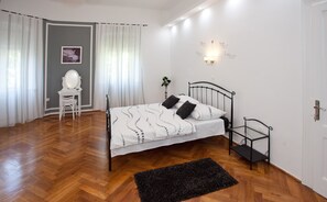 A bedroom with a bed, a chair, a desk, a mirror, and a wall with motivational quotes. - Villa Barbara (Split)