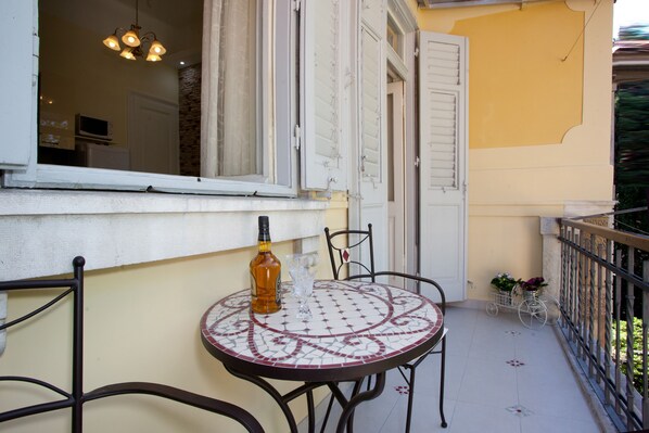 A balcony with a round table, chairs, a bottle, and a glass. - Villa Barbara (Split)