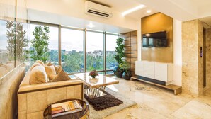 Uma sala de estar moderna com sofá, mesa de centro e TV na parede.