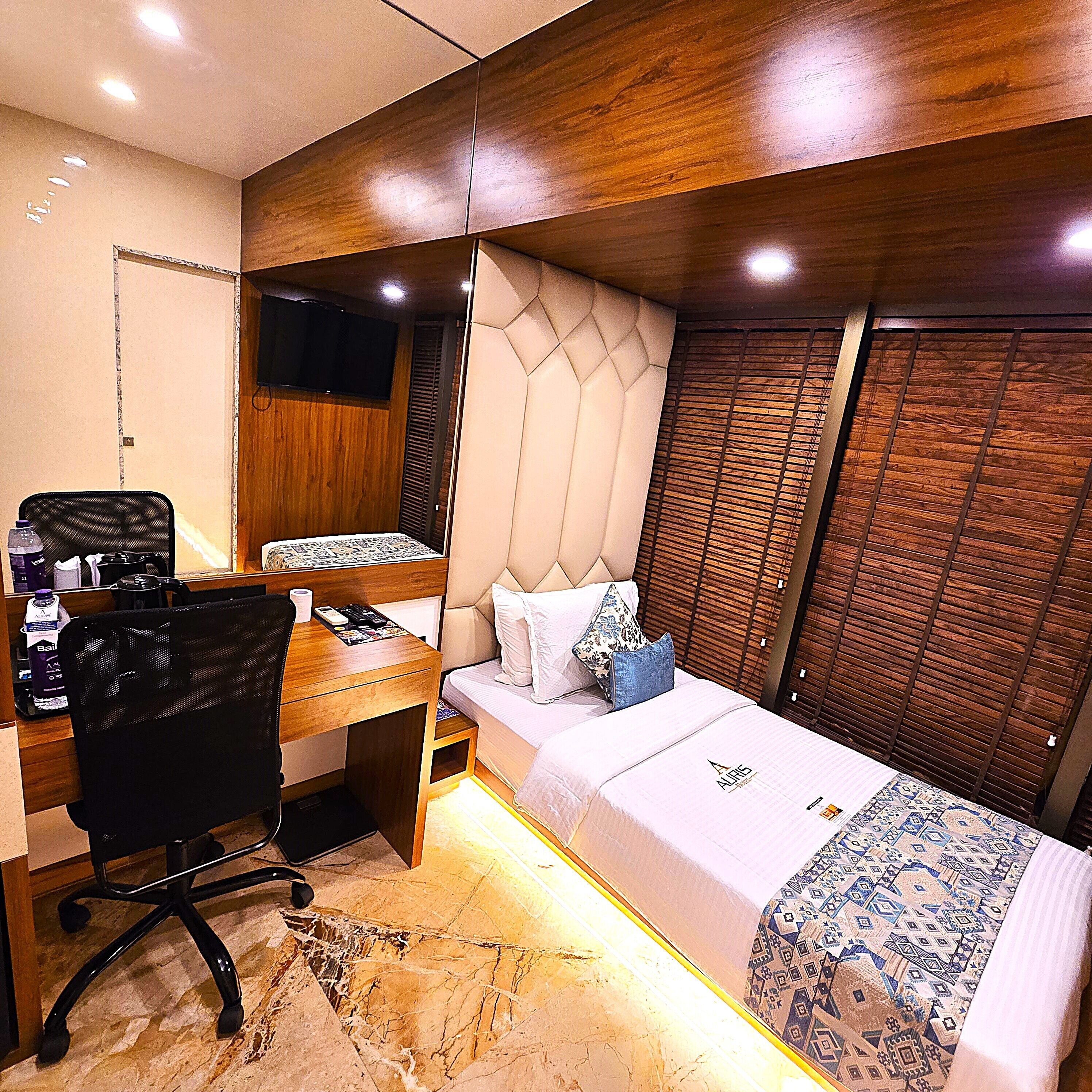 Une chambre à coucher de taille réduite, comprenant un lit, un bureau et une chaise.