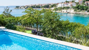A swimming pool with a view of a coastal town and clear blue water. - Cozy Villa in Okrug Gornij with swimming pool and all what is needed (Okrug Gornji)