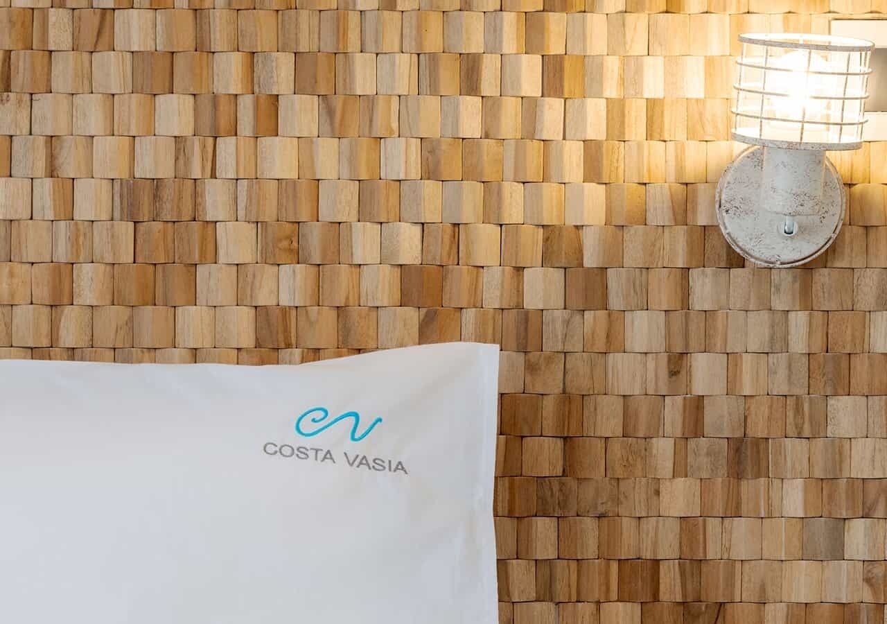 A wall with a woven pattern and a towel with 'COSTA VASIA' text.