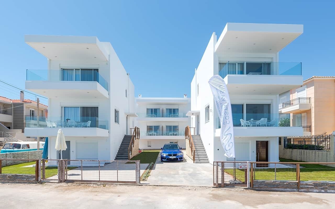 A modern two-story building with a car parked in front.