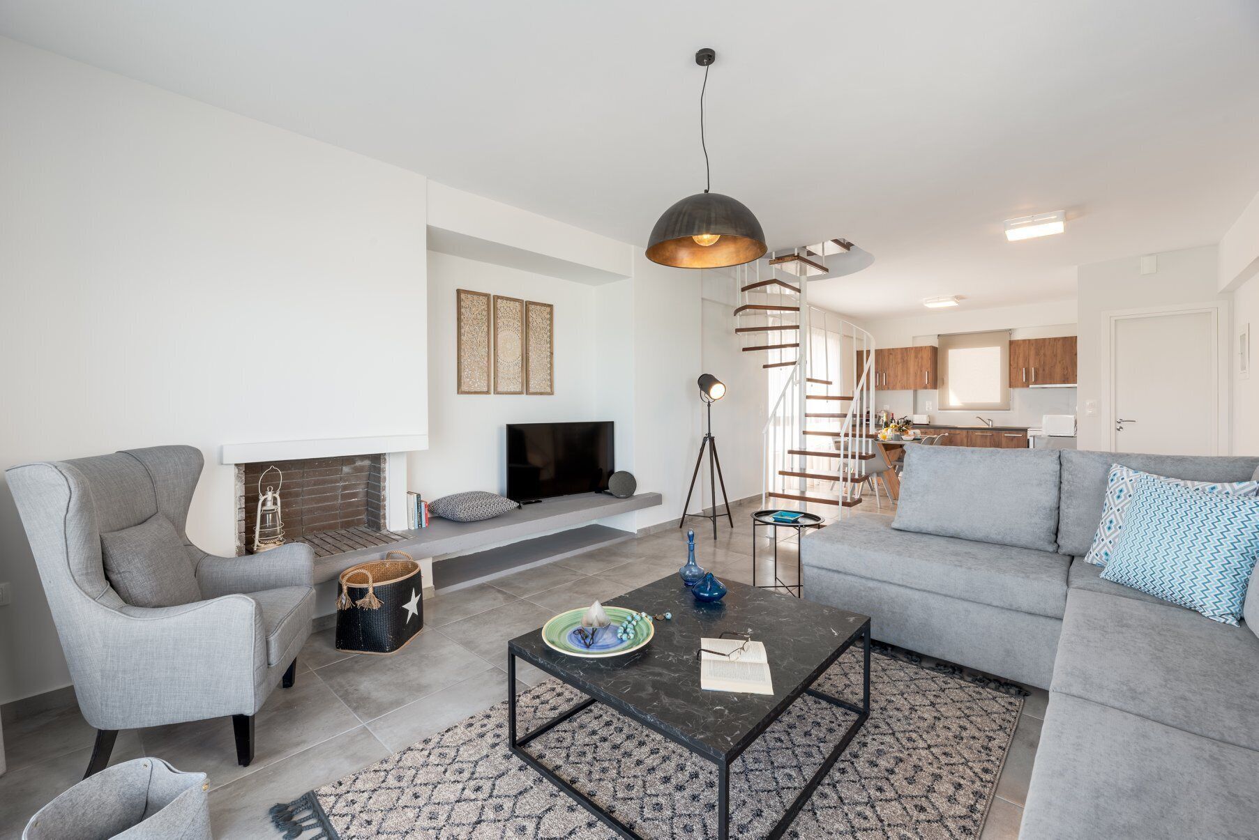 Una sala de estar moderna con chimenea, un sofá, una mesa de centro y un televisor.