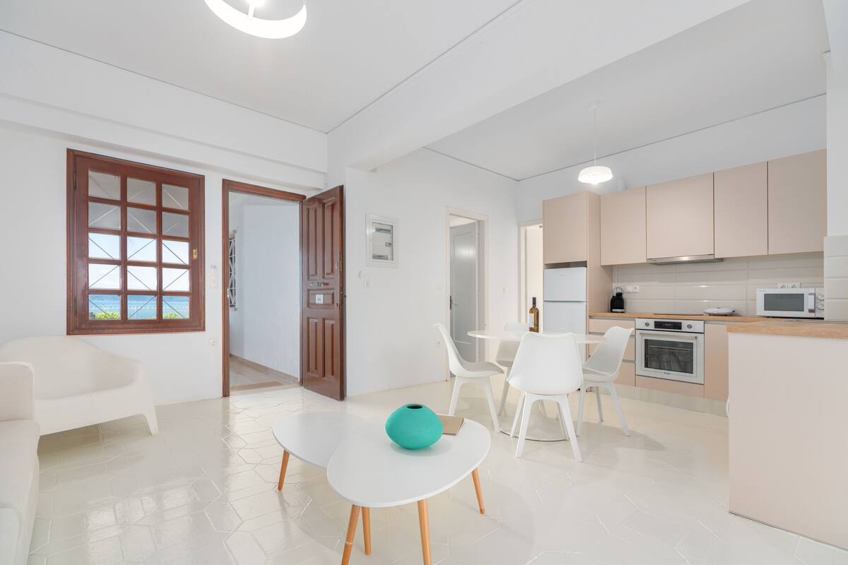 Un apartamento moderno con comedor, cocina y vistas por una puerta.