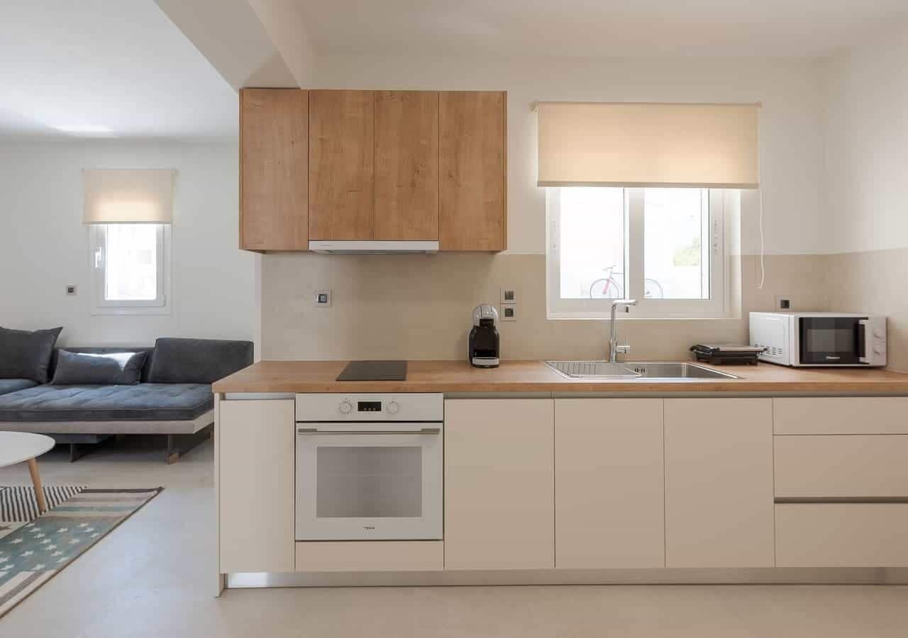 A modern kitchen with a built-in oven, a microwave, and wooden cabinets.