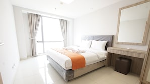 A modern hotel room with a large bed, a bathroom vanity, and a large window with curtains. - Apatel The Mansion Jasmine Aurora 31 I (Jakarta)
