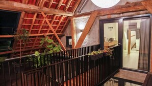 En modern inredning med ett träpanelat tak, en balkong med svarta räcken och ett rum med en skylt som visar ordet ”twa”.