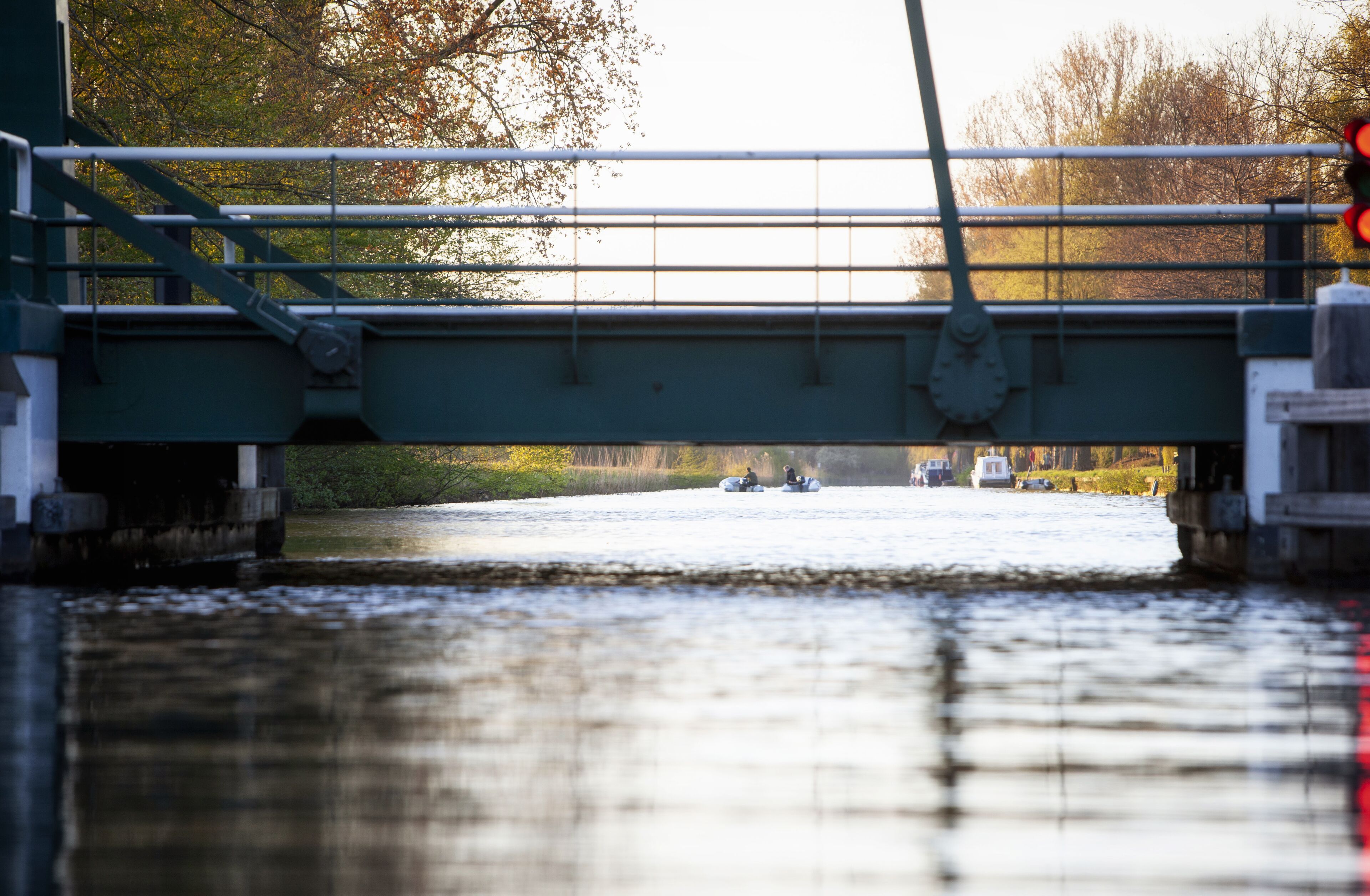 Un pont enjambant une rivière, avec des bateaux et un feu de signalisation.