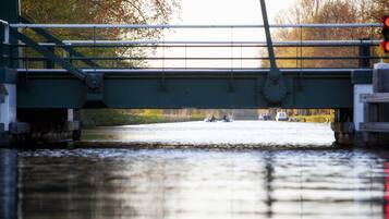 Un pont enjambant une rivière, avec des bateaux et un feu de signalisation.