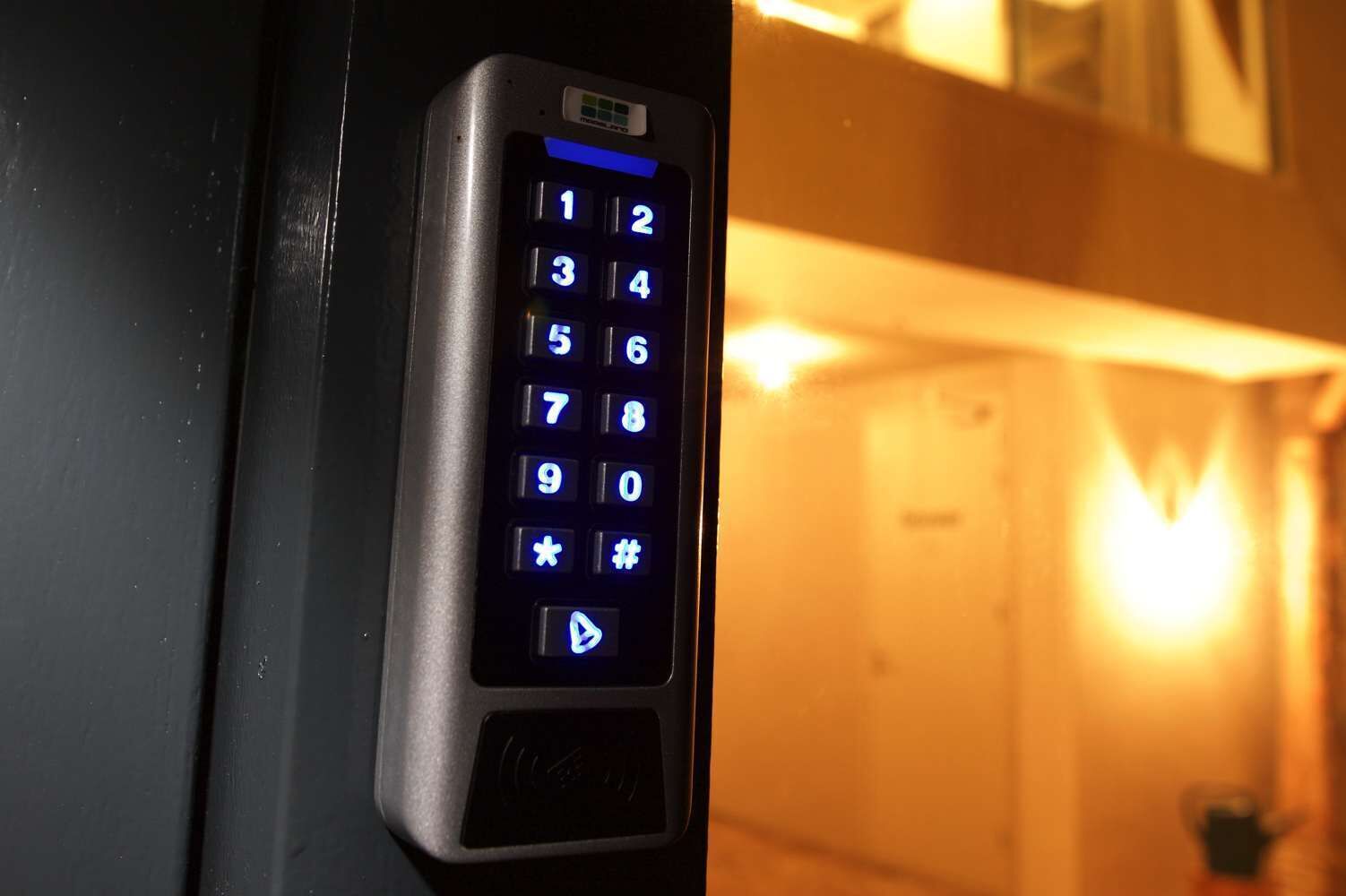 A keypad with illuminated numbers and symbols, likely for a hotel room entry system.