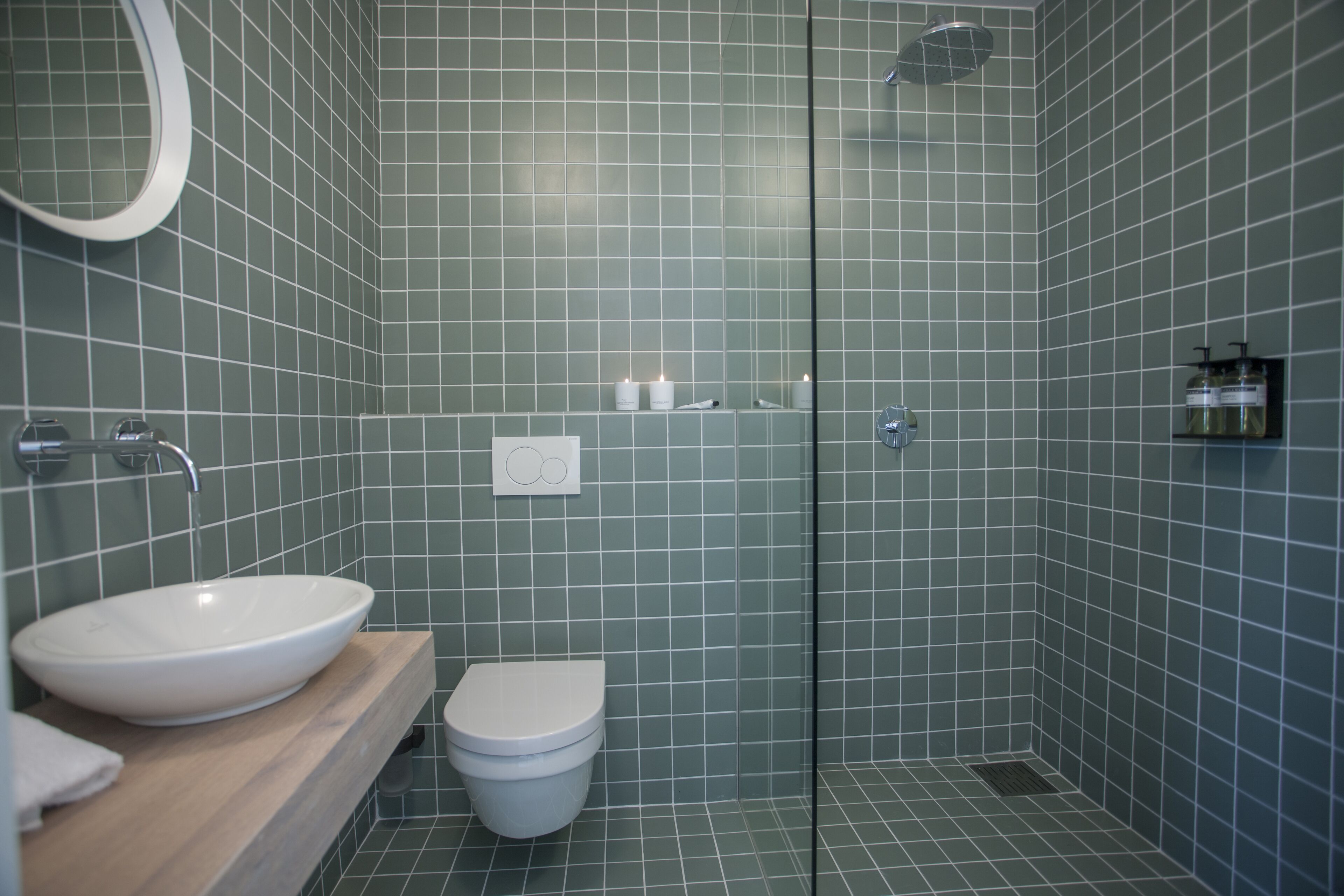 Un baño moderno con lavamanos grande, inodoro y cabina de ducha de vidrio.
