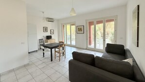 Eine moderne Wohnung mit Essbereich, einer Couch und großen Fenstern.