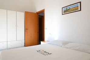 A bedroom with a bed, a wardrobe, and a painting on the wall.
