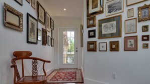 A hallway with a wooden chair, a red patterned rug, and a door leading outside. - Lido Beach Walk! One block to beach! (Sarasota)