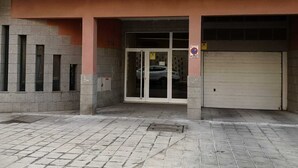 Entrada de un edificio con una puerta de garaje, un hidrante y un letrero de no estacionamiento.