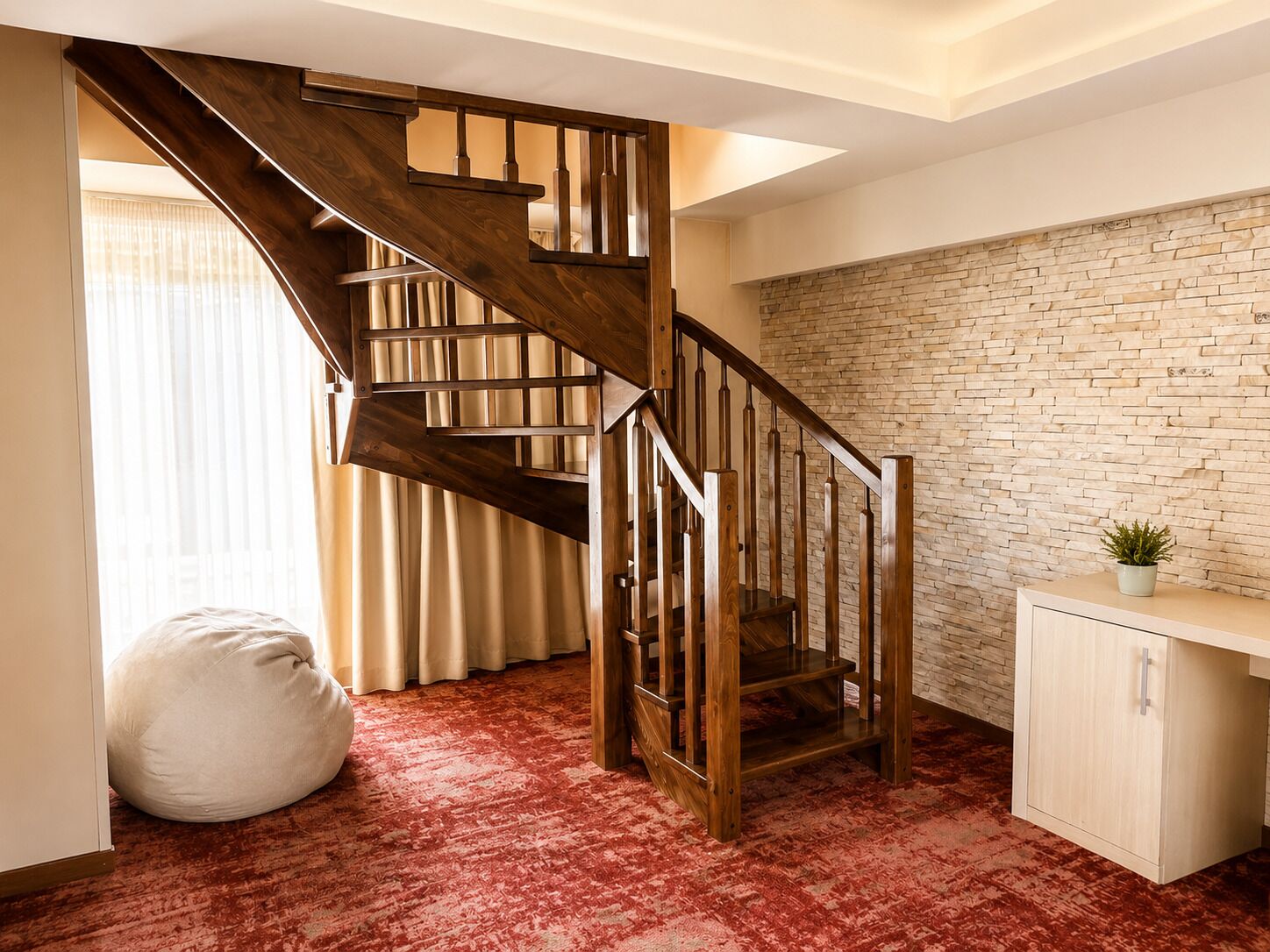 A wooden staircase with a stone wall, a bean bag, and a cabinet.