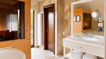 Un baño moderno con una bañera grande, un lavabo doble y un espejo amplio.