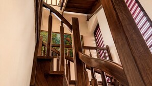 Gradi d'espiral amb barana de fusta i vista d'un quadre penjat a la paret.