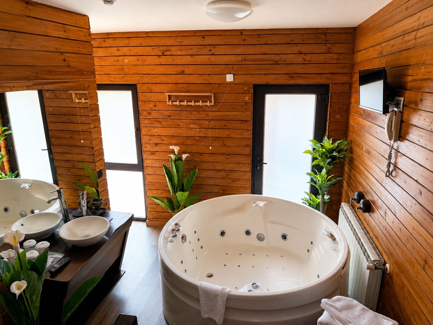 Un interior de madera con una bañera grande, dos lavamanos y un espejo.