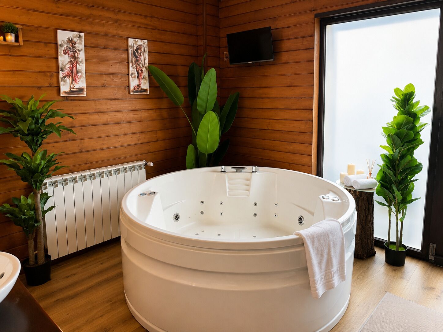 A spa room with a large hot tub, wooden walls, and potted plants.