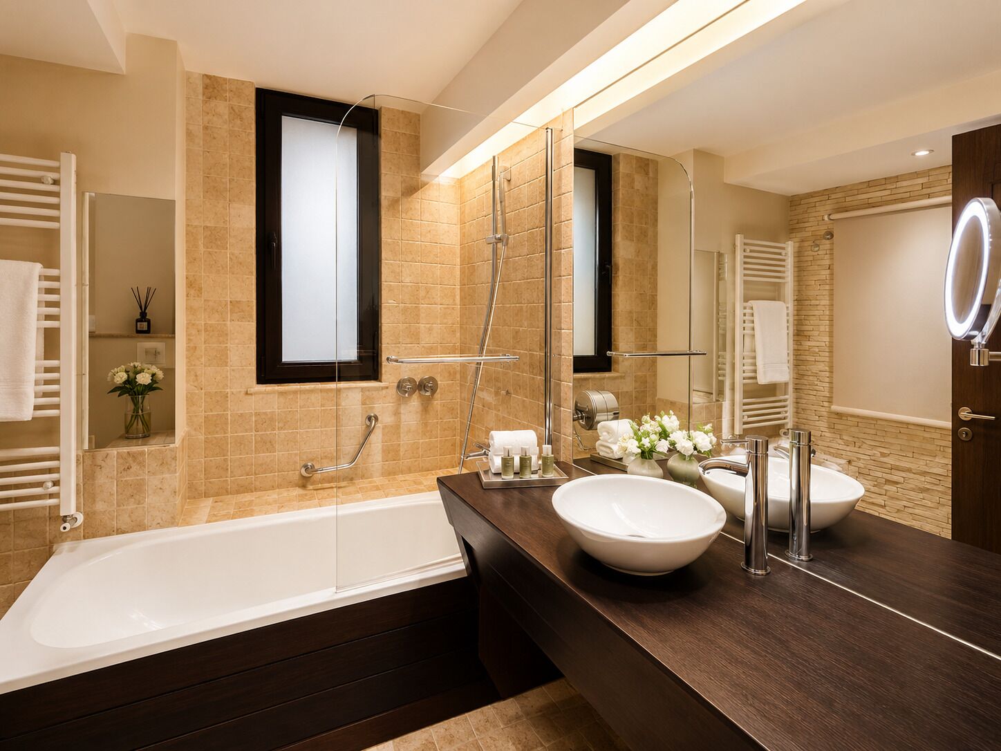 A modern bathroom with a bathtub, two sinks, a large mirror, and a shower.
