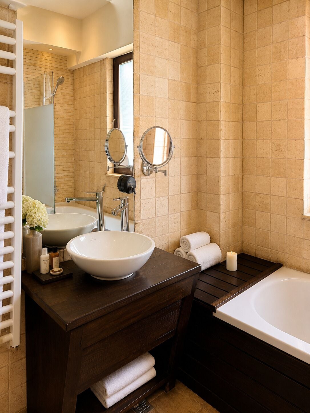 A bathroom with two sinks, a bathtub, a mirror, and a towel rack.