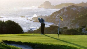 A person on a golf course with a flagstick, surrounded by greenery and rocky terrain. - Hotel Solemare (Bonifacio)