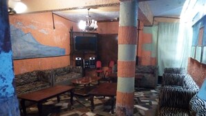 A room with zebra-striped sofas, a tiled floor, and a television set. - Sunset View Complex (Mombasa)