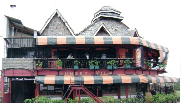 A building with a balcony, potted plants, and a sign that reads "SUNSET VIEW". - Sunset View Complex (Mombasa)