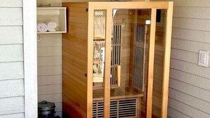 Un espace dédié à un bain à remous, agrémenté d’une structure en bois, d’une étagère pour les serviettes et d’une fenêtre avec des barreaux.