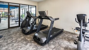 Ein Fitnessraum mit zwei Laufbändern, einem Ergometer und einem Rudergerät.